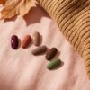 Losse nagelstaaltjes in herfsttinten naast een gebreide trui en een herfstblad